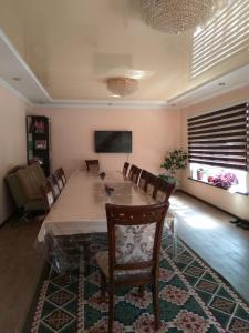 uma sala de jantar com uma grande mesa e cadeiras em Talants Guest House em Bishkek