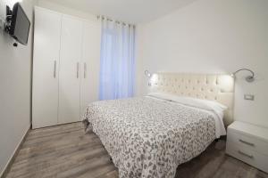 1 dormitorio blanco con 1 cama y armario blanco en Appartamenti Museo, en Verona