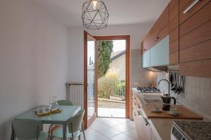 a kitchen with a table and a door to a yard at Holiday House Ars in Gardone Riviera