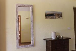 a mirror on a wall next to a wooden dresser at Finca Verde in Llucmajor
