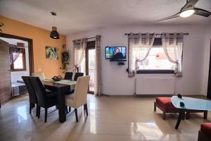 a living room with a table and chairs and a tv at sunny in Ayios Nikolaos Sithonia