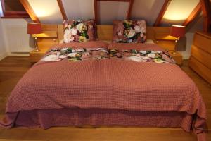 a bedroom with a bed with a red comforter at B&B Kamperfoelie in Gorssel