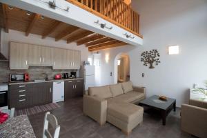 uma sala de estar com um sofá e uma cozinha em Villa de la Mer em Agios Stefanos