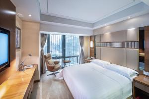 a hotel room with a large bed and a television at Galaxy minyoun Chengdu Hotel in Chengdu