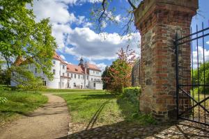 an old brick building with a gate in front of it at Schlosshotel Fürstlich Drehna in Fürstlich Drehna