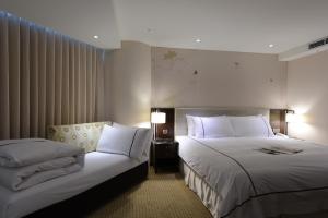 Tempat tidur dalam kamar di K Hotel Taipei Dunnan