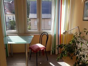 une table en verre et une chaise devant une fenêtre dans l'établissement Ferienwohnungen Vier Jahreszeiten, à Thale