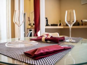 una mesa con dos copas de vino y servilletas. en Turenum Apartment B&B, en Trani