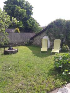 zwei Stühle im Gras im Garten in der Unterkunft Babamúzeum kis apartman in Tihany