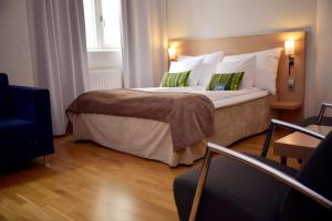 um quarto de hotel com uma cama grande com almofadas verdes em Clarion Collection Hotel Savoy em Oslo