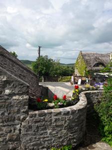 a stone wall with flowers in front of a building at Babamúzeum 4 fős apartman in Tihany