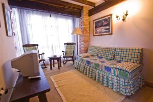 een woonkamer met een bank en een tafel met een tv bij Vivienda Casa Luisa in Comillas