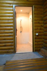puerta abierta a un baño con ducha en Dvorik en Chernivtsi