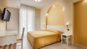 um pequeno quarto com uma cama e uma televisão em Hotel Il Gabbiano em Cesenatico