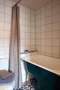 a bathroom with a bath tub and a toilet at Chez les Amis in Saint-Nazaire-de-Ladarez