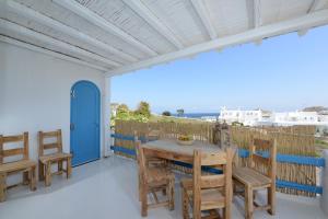 Una mesa y sillas en un balcón con vista al mar. en Luxury White Maisonette, en Kalafatis
