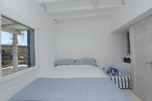 Una cama en una habitación blanca con ventana. en Luxury White Maisonette, en Kalafatis 21 fotos más