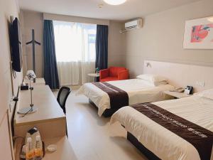 Cette chambre d'hôtel comprend deux lits et un fauteuil rouge. dans l'établissement Jinjiang Inn Yixing Middle Renmin Road Pedestrain, à Yixing