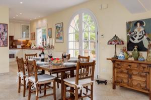 a dining room with a table and chairs and a kitchen at Patio de los Gatos in Tamariu