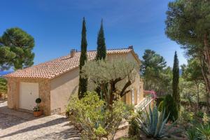a house in a garden with trees and bushes at Patio de los Gatos in Tamariu