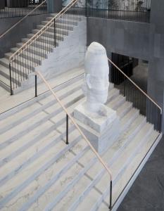 a statue sitting on the stairs of a building at At Six in Stockholm