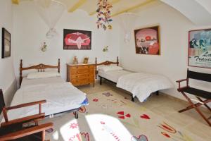 a bedroom with two beds and a dresser at Patio de los Gatos in Tamariu +10 photos