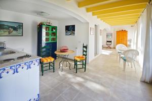 a kitchen and living room with a table and chairs at Patio de los Gatos in Tamariu