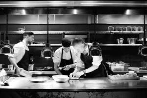 a group of people in a kitchen preparing food at At Six in Stockholm