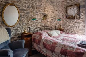 a bedroom with a bed and a mirror and a chair at Chez les Amis in Saint-Nazaire-de-Ladarez