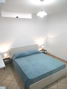 レウカにあるCasa vacanza Leucaのベッドルーム1室(青いベッド1台、ナイトスタンド2台付)
