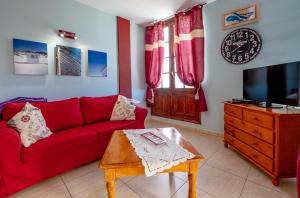 - un salon avec un canapé rouge et une table dans l'établissement La Niña - Ocean View Apartment, à Arona
