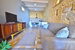 a living room with a couch and a television at Eight Point Living 6B in Birgu