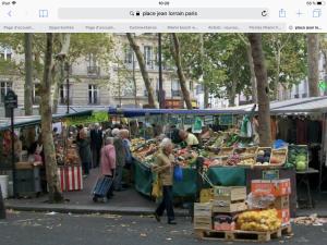 a group of people walking around a farmers market at Large studio eiffel tower in Paris