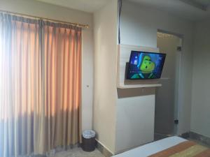 Una televisión o centro de entretenimiento en Hotel Grand Rosela