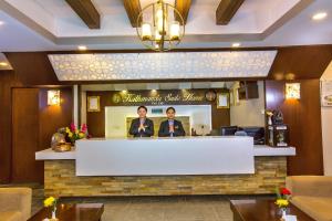 Kathmandu Suite Home في كاتماندو: رجلان يقفان خلف مكتب في مطعم