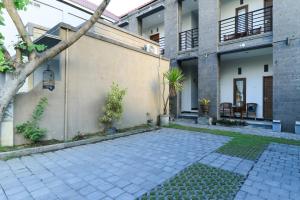 a courtyard of a house with a patio at Hotel Warta Putra in Denpasar