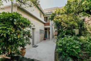 a walkway leading to a house with trees and bushes at Boka Apartment 4 in Herceg-Novi