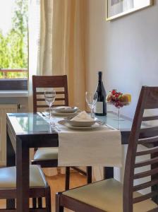 a dining room table with two chairs and a table with wine glasses at Apartamenty Łagiewniki in Krakow