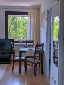 comedor con mesa, sillas y ventana en Apartamenty Łagiewniki, en Cracovia