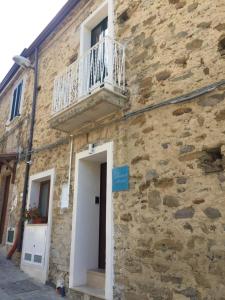 a stone building with a balcony and a door at La Torretta di Alessia in Ogliastro Cilento
