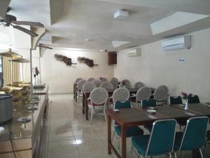 a dining room with tables and chairs in it at Hotel Grand Rosela in Yogyakarta