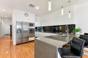 a kitchen with a stainless steel refrigerator and a counter at BENGALEE EXECUTIVE TOWNHOUSE- MODERN & STYLISH in Mount Gambier