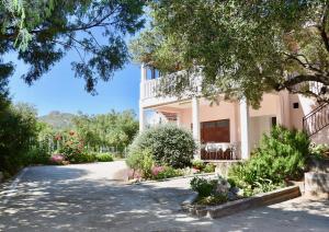 a villa with a garden and a driveway at Guesthouse Jasna in Slano