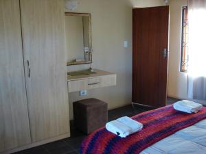 a bedroom with a bed and a sink and a mirror at 677Hornbill in Marloth Park +25 photos