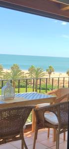 d'une table et de chaises sur un balcon avec vue sur la plage. dans l'établissement Mirando al mar. Primera linea de playa, à Isla Canela