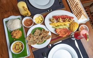 a table with plates of food on a table at Ayur Ayur Resort & Ayurveda Retreat in Negombo