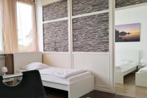 een slaapkamer met een bed en een bakstenen muur bij Work & stay Langenfeld in Langenfeld