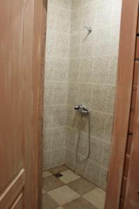 a bathroom with a shower with a tiled floor at Hostel v Dnepropetrovske Grunge in Dnipro