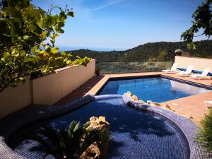 a swimming pool with a view of the ocean at La Roqueta Hotel in Tossa de Mar