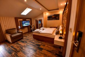 a bedroom with a bed and a chair and a television at ŞERAH APART otel in Uzungöl
